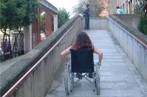 Estudiante en silla de ruedas subiendo una rampa