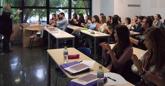 People in a classroom communicating in sign language.