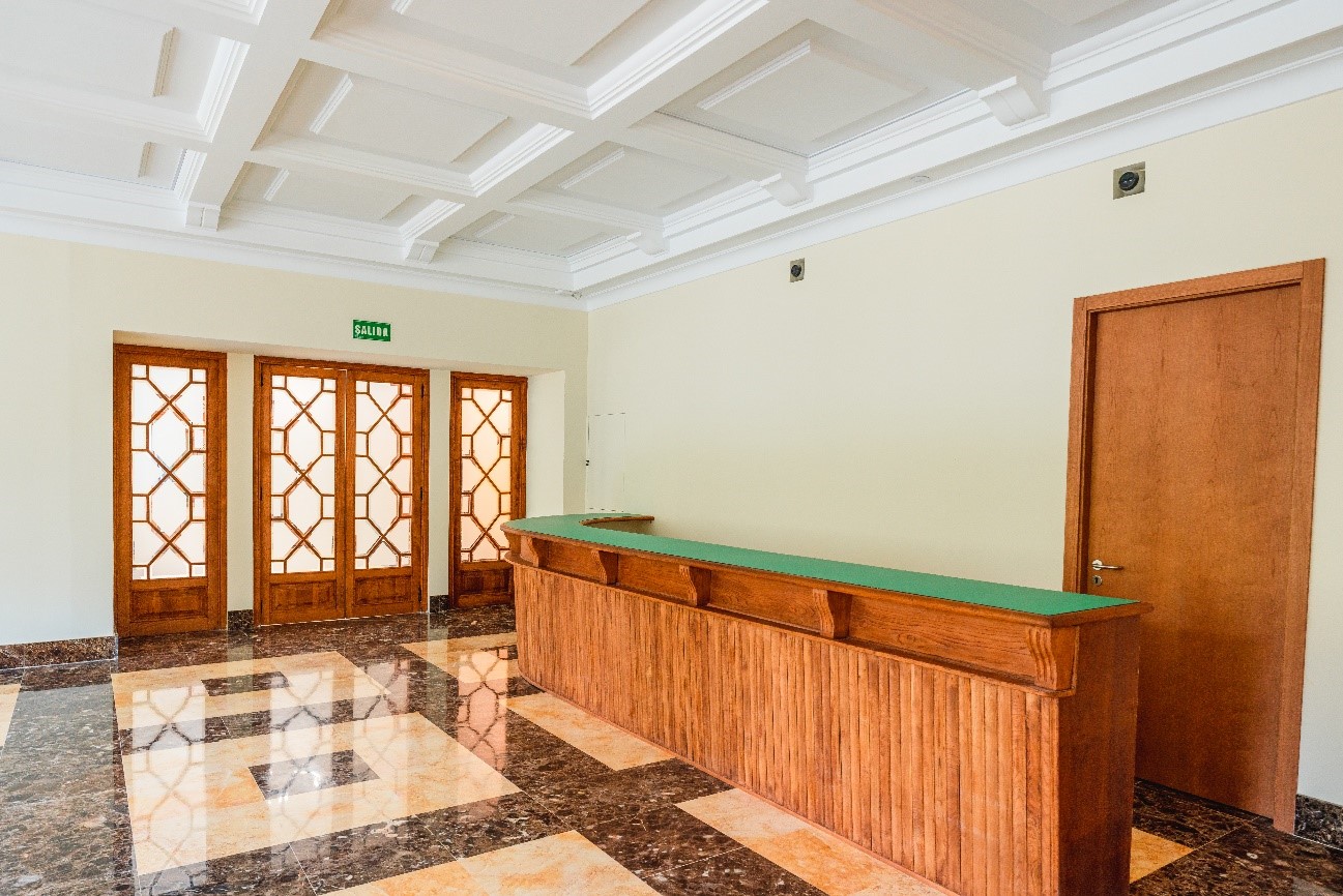 Espacio del bar, se ve la barra y la puerta de entrada