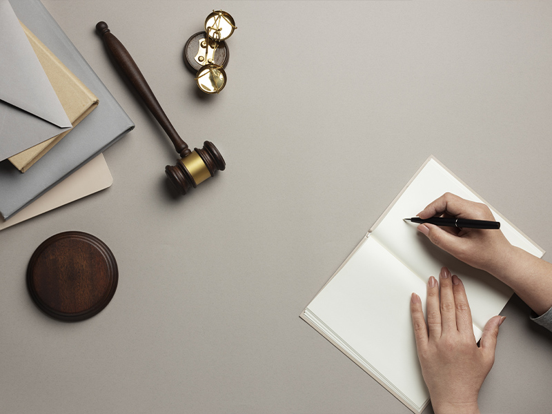 Juez/a escribiendo en una libreta